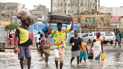 People carry their personal effects through a flooded section of Praia Nova, Beira, Mozambique. IFRC/EPA