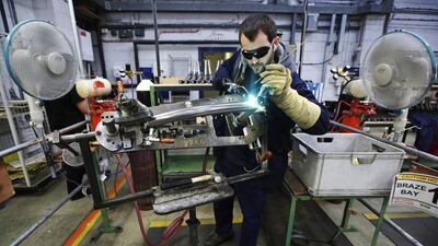 A worker brazes a bike frame at a bicycle factory in west London. UK manufacturing has slowed so far this year. Luke MacGregor / Reuters