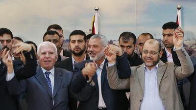Senior Fatah official Azzam Al Ahmed (L), head of the Hamas government Ismail Haniyeh (C) and senior Hamas leader Moussa Abu Marzouq hold their hands after announcing a reconciliation agreement in Gaza City on April 23. Suhaib Salem / Reuters