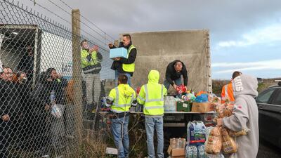 Volunteers distribute fresh food and supplies over a perimeter fence to truck drivers at Manston airport in Manston, U.K. Routes to Dover, Britain's busiest cross-channel port, have been choked for days after France shut its border with Britain, blaming an outbreak of a novel strain of the coronavirus. Bloomberg