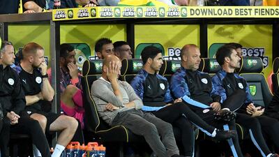 Manchester City manager Pep Guardiola looks dejected on the bench with his backroom staff. PA