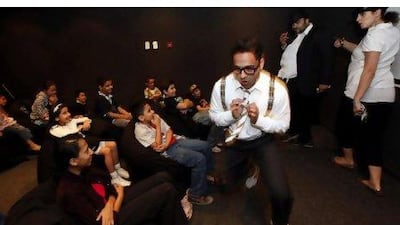 Salman Qureshi, portraying Professor Stanolio, leads his fellow actors Ali al Sayed and Mina Liccianne in a skit prior to a film showing for children in Sharjah.