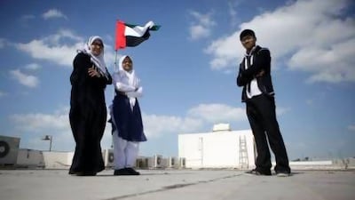 From left: Roksana Akther, 18, Afifa Kochi, 18, and Iqbal Mahmood, 17, stand on the roof of their school. Sammy Dallal / The National