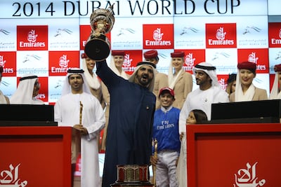 Sheikh Mohammed bin Rashid, Vice President of UAE and Ruler of Dubai, lifts the 2014 Dubai World Cup, flanked by winning jockey Silverstre de Sousa, right, and Saeed bin Suroor, the trainer. Pawan Singh / The National