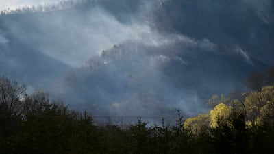 Firefighters from across Tennessee continued working on Thursday morning to contain a wildfire near the Great Smoky Mountains National Park that spread overnight despite rain from storms that passed through the area. Knoxville News Sentinel / AP