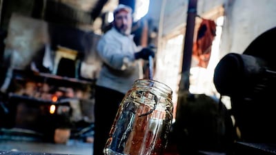 A glassblower forms glass at factory, which is recycling the broken glass as a result of the Beirut explosion, in the northern Lebanese port city of Tripoli. AFP