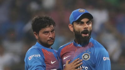 India's captain Virat Kohli, right, celebrates the dismissal of West Indies Shimron Hetmyer with Kuldeep Yadav during the third Twenty20 in Mumbai on Wednesday. AP