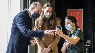 Prince William and Catherine, Duchess of Cambridge speak with the family of paramedic Jahrin Khan via a mobile phone. AP Photo