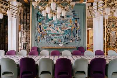 The grand, mirrored dining room doubled as a board room for important meetings. A hand-woven mergoum with a fishing scene covers one wall. Erin Clare Brown / The National