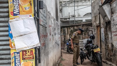 A police sniffer dog is led around the area next to Dawatagaha Jumma Masjid in Colombo. Getty Images