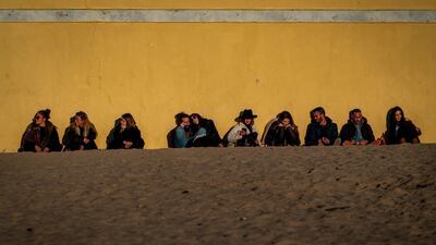 People sit as they look at the sunset on a beach at the city of Cadiz in Andalucia, Southern Spain. AP Photo