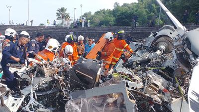 Rescuers inspecting the crash site after two military helicopters collided in Lumut in Malaysia's Perak state. AFP