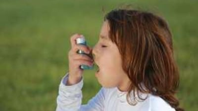 A child using an asthma inhaler.