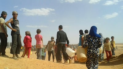 Syrian refugees gather to receive water at the Rukban camp on the Jordan-Syria border on June 23, 2016. AP Photo