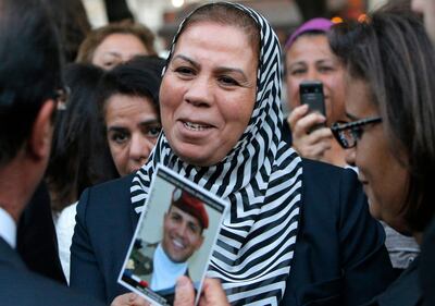 Latifa Ibn Ziaten shows a photograph of her son killed by Mohamed Merah, to France's President Francois Hollande. AFP