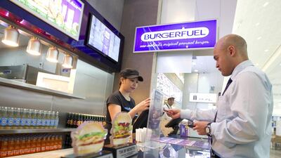 Mirchelle Pamintuan takes customer Glenn Gawler's lunchtime order at BurgerFuel in Mirdif City Centre, Dubai. Sarah Dea / The National