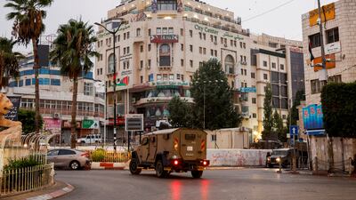A military vehicle moves in a street outside the building that is home to Al Jazeera office, in Ramallah, in the Israeli-occupied West Bank. Reuters