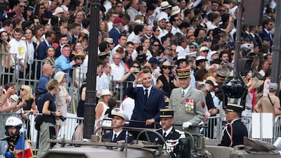 Mr Macron and Thierry Burkhard, Chief of Staff of the Armed Forces, driving down the Champs-Elysees. AP