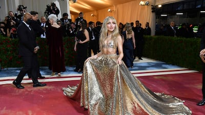 Singer and actress Sabrina Carpenter wearing a gold skirt and bralette top. AFP
