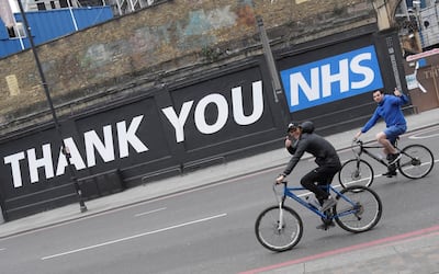Cyclists gesture as they pass a thank you message for the NHS in East London following the outbreak of the coronavirus, London, Britain, May 10, 2020. REUTERS