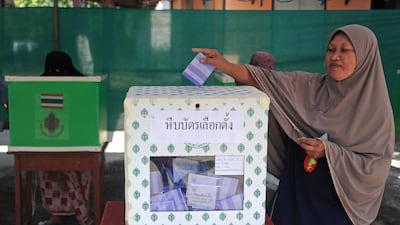A woman casts her vote in a ballot box at a polling station in Narathiwat province. Voting began in Thailand's troubled election but anti-government protesters forced the closure of more than 10 per cent of polling stations nationwide, an election commission official said. AFP