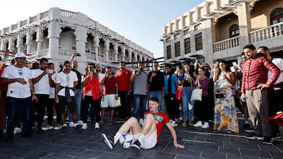 A fan performs with a football in Souq Waqif. Reuters