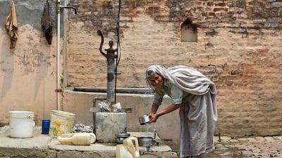 An elderly Indian villager washes utensils with contaminated water at a borewell in the village of Gangnauli in the northern state of Uttar Pradesh. Sajjad Hussain Wani/AFP