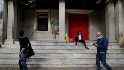 People pass in front of a beggar, centre, on Hamra Street. Fuelled by massive debt and the unsustainable way it was financed, the crisis has slashed Lebanon's gross domestic product by 58.1% since 2019, the World Bank said.