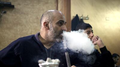 Jordanians smoke shisha late into the night at a coffee shop in Amman. Mohammed Hannon / AP Photo