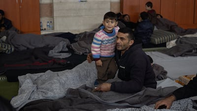 A child and his father shelter in a displacement centre set up in Zein Al Abidien Mosque, Aleppo