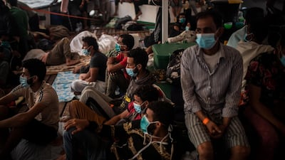 Migrants of different nationalities rest on board the Spanish NGO Open Arms vessel, after being rescued as they were trying to flee Libya on board a precarious wooden boat, in the Central Mediterranean Sea, Amnesty International said on September 24, 2020. AP