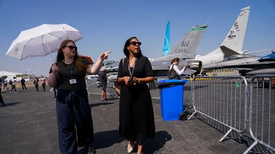 Visitors shelter from the sun as they look around the show. AP