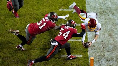 Washington Football Team quarterback Taylor Heinicke (4) dives towards the end zone to score a touchdown against Tampa Bay Buccaneers inside linebackers Kevin Minter (51) and Lavonte David (54) during the second half of an NFL wild-card playoff football game, in Landover, Maryland. AP Photo