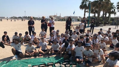 Year Five students at Umm Sequim Beach, Dubai, with the some of the cigarette butts they discovered during a clean-up.