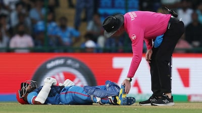 The umpire checks on Afghanistan's Hashmatullah Shahidi to see if he needs medical attention. Reuters