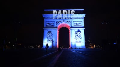The Arc de Triomphe building is lit up in blue and a projection of the word 'Paris' as part of New Year's Eve celebrations in Paris on December 31, 2022. AFP