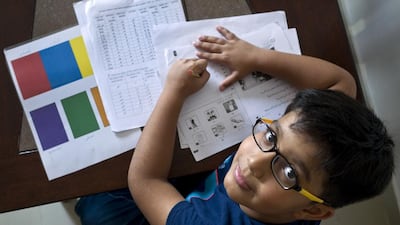 Nine-year-old Ayaan Khan, who is left-handed, works on his Arabic studies homework in Abu Dhabi in 2016. Delores Johnson / The National