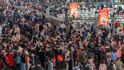 Travelers wearing face masks to protect against COVID-19 line up for trains at a station in Guangzhou in southern China's Guangdong Province, Friday, Jan. 28, 2022. Chinese are traveling to their hometowns for the Lunar New Year, the country's biggest family holiday, despite a government plea to stay where they are as Beijing tries to contain coronavirus outbreaks. (Chinatopix via AP)
