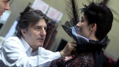 Italian designer Emanuel Ungaro makes last-minute preparations backstage prior to the presentation of his 2001/2002 autumn-winter Haute Couture collection in Paris, France July 9, 2001. REUTERS/Philippe Wojazer/File Photo