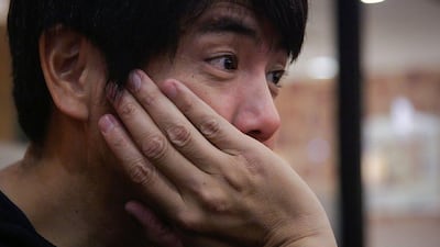 Takanobu Nishimoto of "Ossan Rental" listens to a client in Tokyo. Quentin Tyberghien / AFP Photo