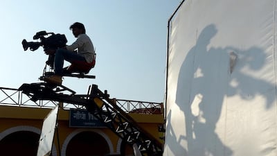 The shadow of a cinematographer falls onto a screen during a shoot on a set inside Film City in Mumbai. AFP PHOTO/ INDRANIL MUKHERJEE
