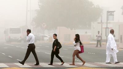 Pedestrians brave the dust near Marina Mall in Abu Dhabi. Christopher Pike / The National