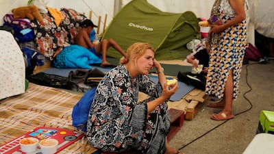 A mother of four eats an apple at a tent for women and children who have arrived in Ceuta from Morocco. Reuters