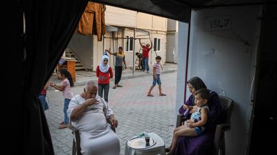 A Syrian family sits in front of their home in the camp. Getty Images