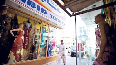 A solitary man walks by Abid Textiles, one of the oldest fabric stores on the Old Jawazaad road in Al Ain, epitomising another day of slow trade at the souq.