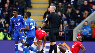 Pogba reacts after sustaining an injury while Leicester City's Demarai Gray looks on. Reuters