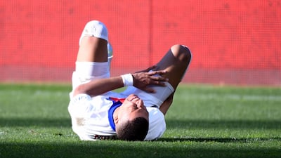 Paris Saint-Germain's French forward Kylian Mbappe reacts in pain during the match against Metz. AFP