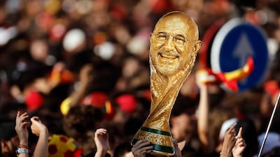 A supporter holds up a cardboard trophy cutout with coach Spain De la Fuente's face. AFP