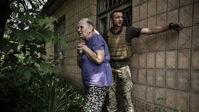 An elderly woman reacts as Ukrainian soldiers lead her to safety during a battle with Russian troops in Lysychansk. AFP