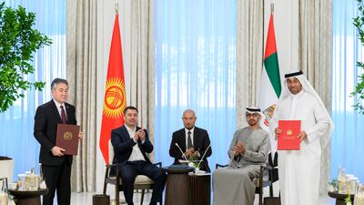 Ahmed Al Sayegh, UAE Minister of State, and Zheenbek Kulubaev, Minister of Foreign Affairs of Kyrgyzstan, exchange agreements.